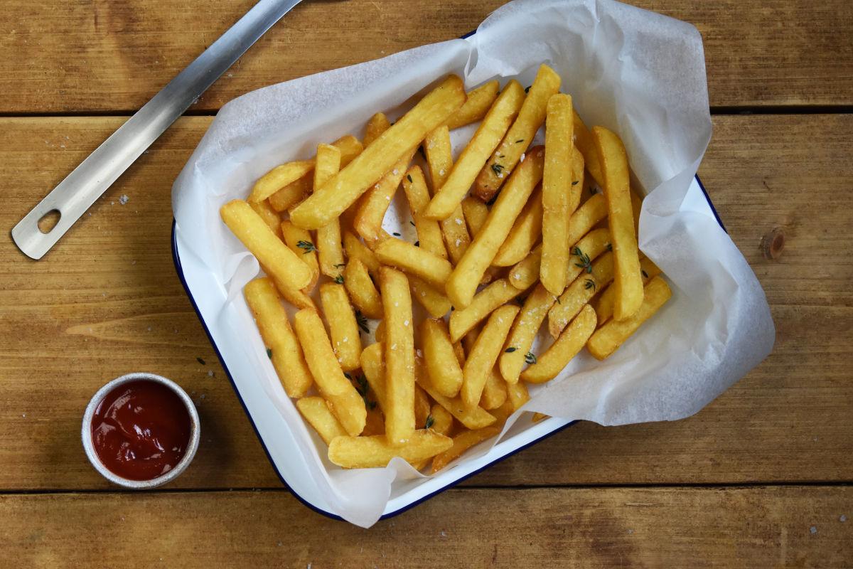 aviko supercrunch pommes serviert in einer schale auf einem holztisch