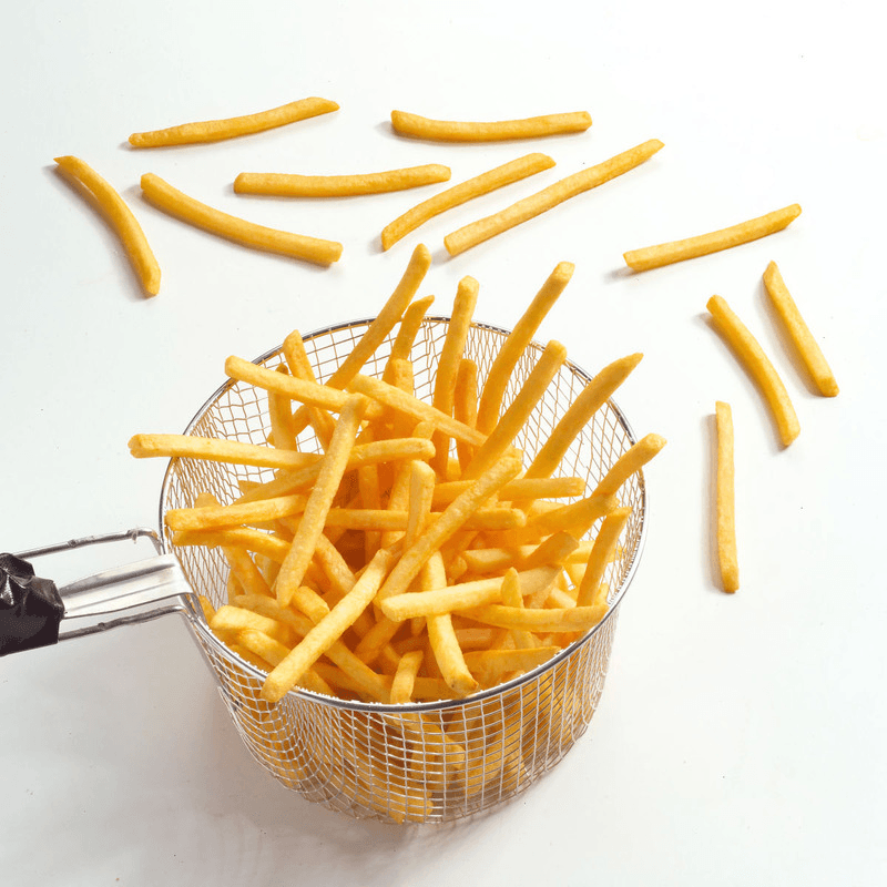 Knusprige dünne Pommes im Heissluftfritteusen-Korb auf weissem Hintergrund