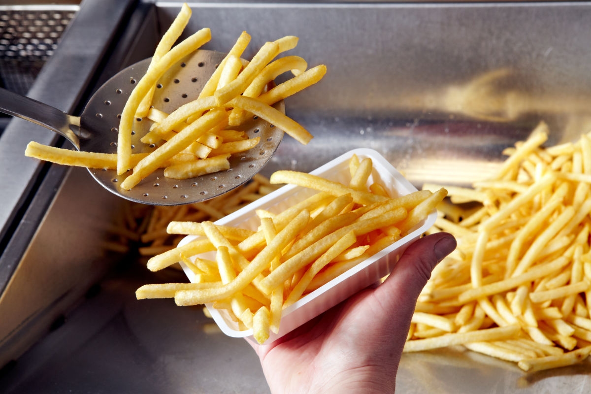 Aviko Pommes werden aus der Fritteuse in Schale gehoben
