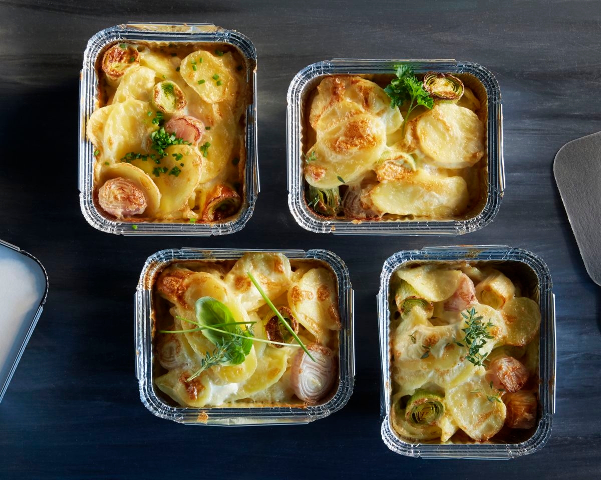 aviko portionsgratins in lieferschalen auf deunklem tisch