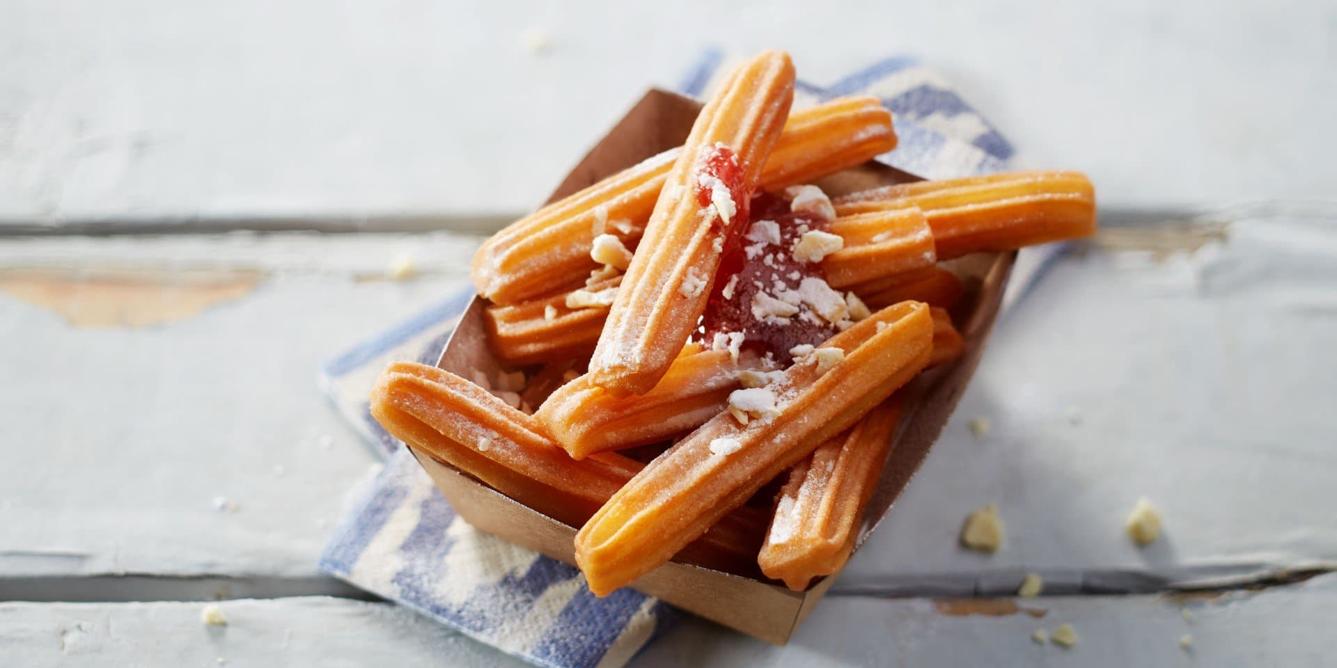 Churros mit Erdbeersauce und weißen Schokoladenraspeln